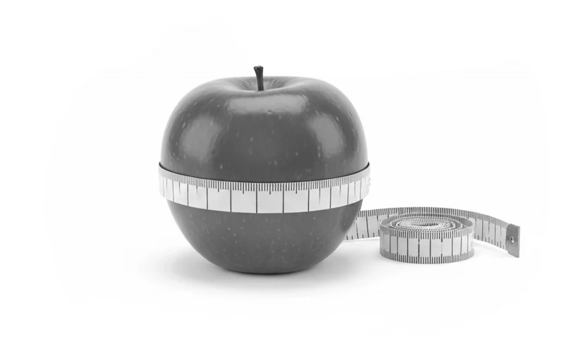 Apfel umwickelt mit einem Maßband