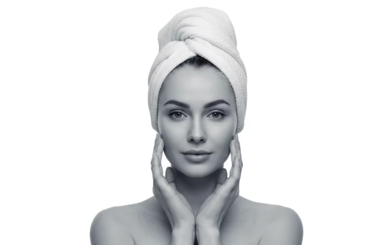 Frau fühlt ihre weiche Haut im Gesicht mit ihren Händen