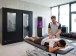 Die Druschke Kältekammer steht in einem Recoveryzentrum von einem Fußballverein. 2 Spieler werden gerade von einem Physiotherapeuten behandelt.